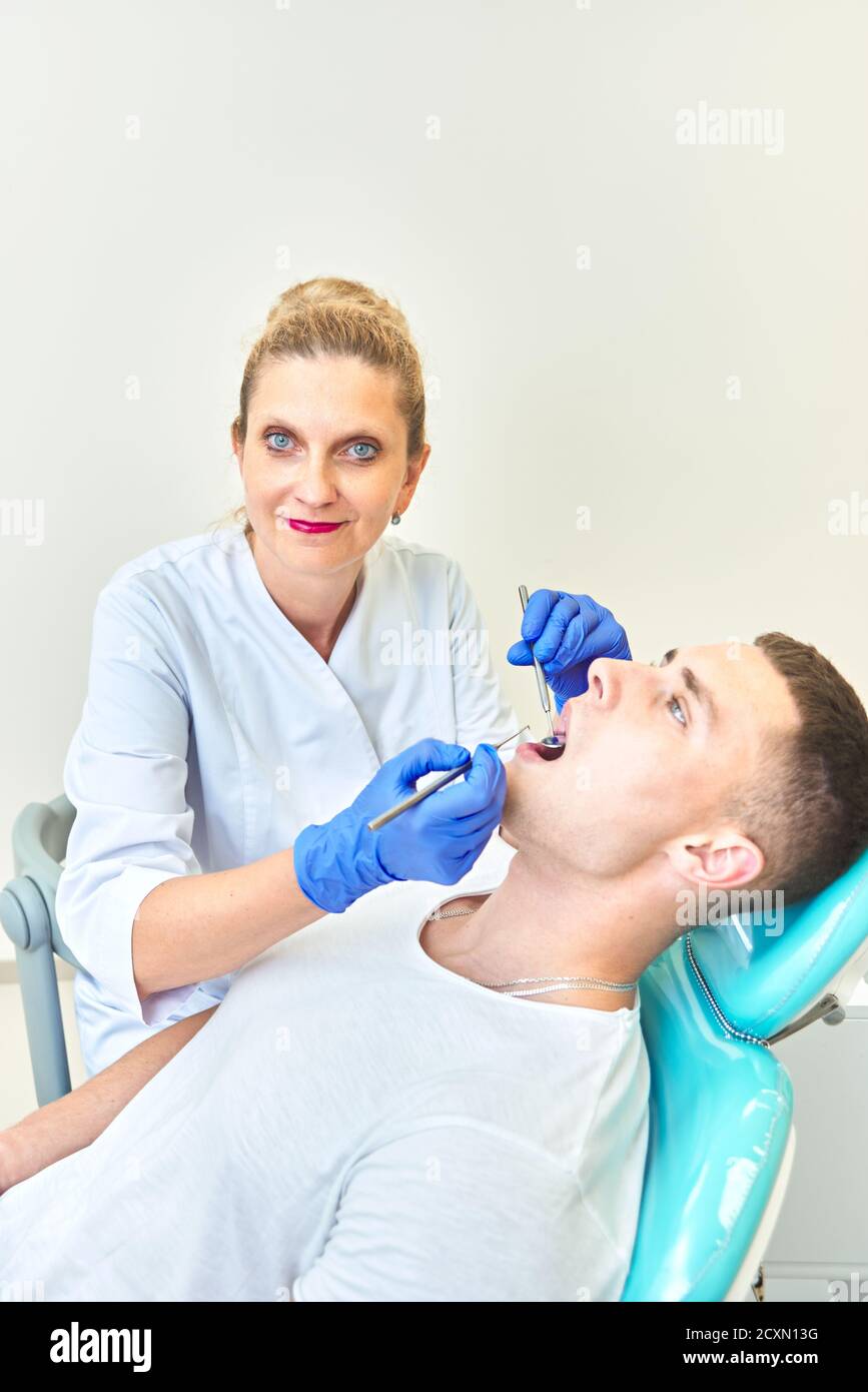 dentist doctor examines the mouth of a young guy. man at the