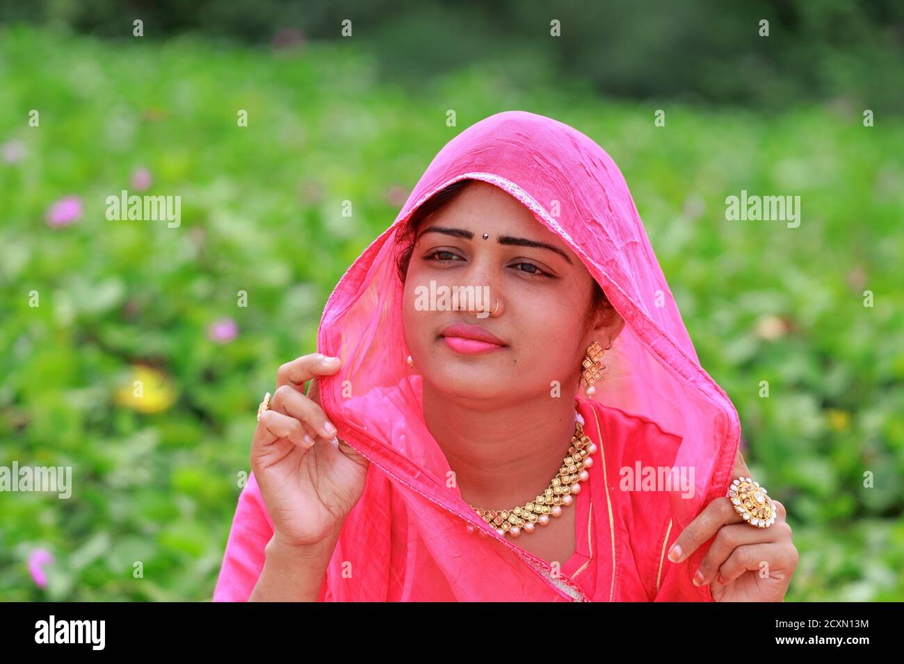 close-up portrait of An Indian young attractive stylish blonde woman posing in outdoors nature in summer fashion style traditional dress wearing rajpu Stock Photo