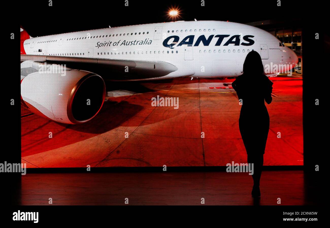 A Qantas employee is silhouetted against a projection of a Qantas A380 before a fashion show to present the new company uniform in Sydney April 16, 2013. Qantas unveiled its new uniforms designed by Australian designer Martin Grant. REUTERS/Daniel Munoz (AUSTRALIA - Tags: FASHION BUSINESS) Stock Photo