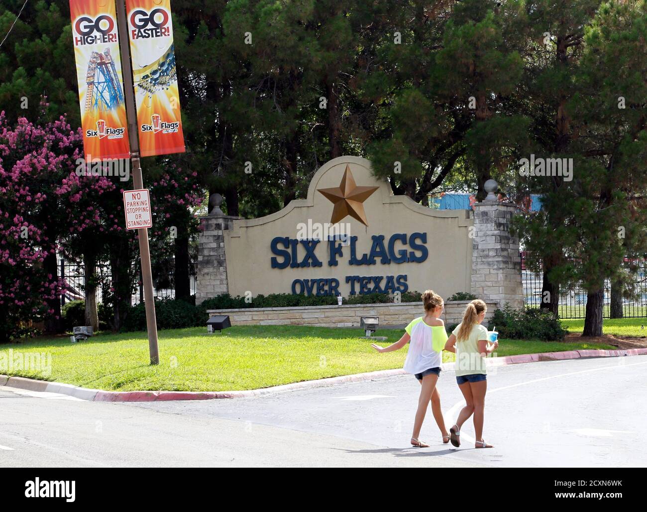 Two girls walk past the entrance of the Six Flags Over Texas amusement park in Arlington, Texas July 23, 2013.  A woman who plunged from the Texas Giant roller coaster ride at the Six Flags Over Texas amusement park died of multiple traumatic injuries in a fall that was ruled an accident, authorities said on Monday.  REUTERS/Mike Stone (UNITED STATES - Tags: SOCIETY) Stock Photo