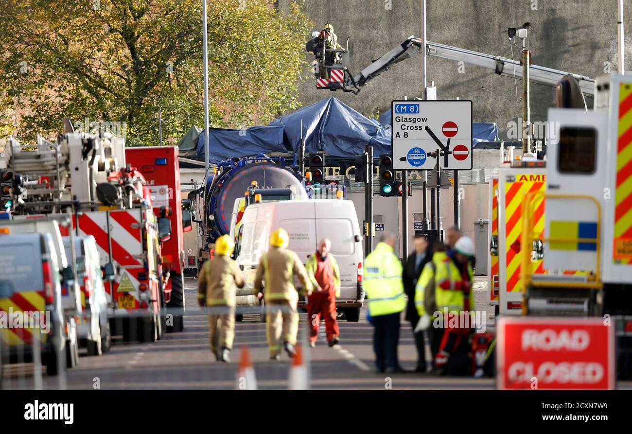 Rescue workers survey the wreckage of a police helicopter which crashed onto the roof of the Clutha Vaults pub in Glasgow, Scotland November 30, 2013. At least one person was killed and 32 injured when the police helicopter crashed into the roof of the packed Glasgow pub, trapping many inside in choking dust and debris. The death toll is expected to rise, Scottish police said. Witnesses said the helicopter dropped from the sky like a stone onto the busy Clutha Pub in Scotland's biggest city at 10:25 p.m. on Friday night as over 100 people listened to a live music concert. REUTERS/Russell Cheyn Stock Photo