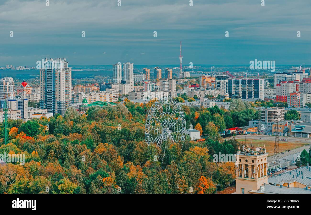 View of the central park of Perm from a height. Ferris wheel among green trees. City skyline. Stock Photo