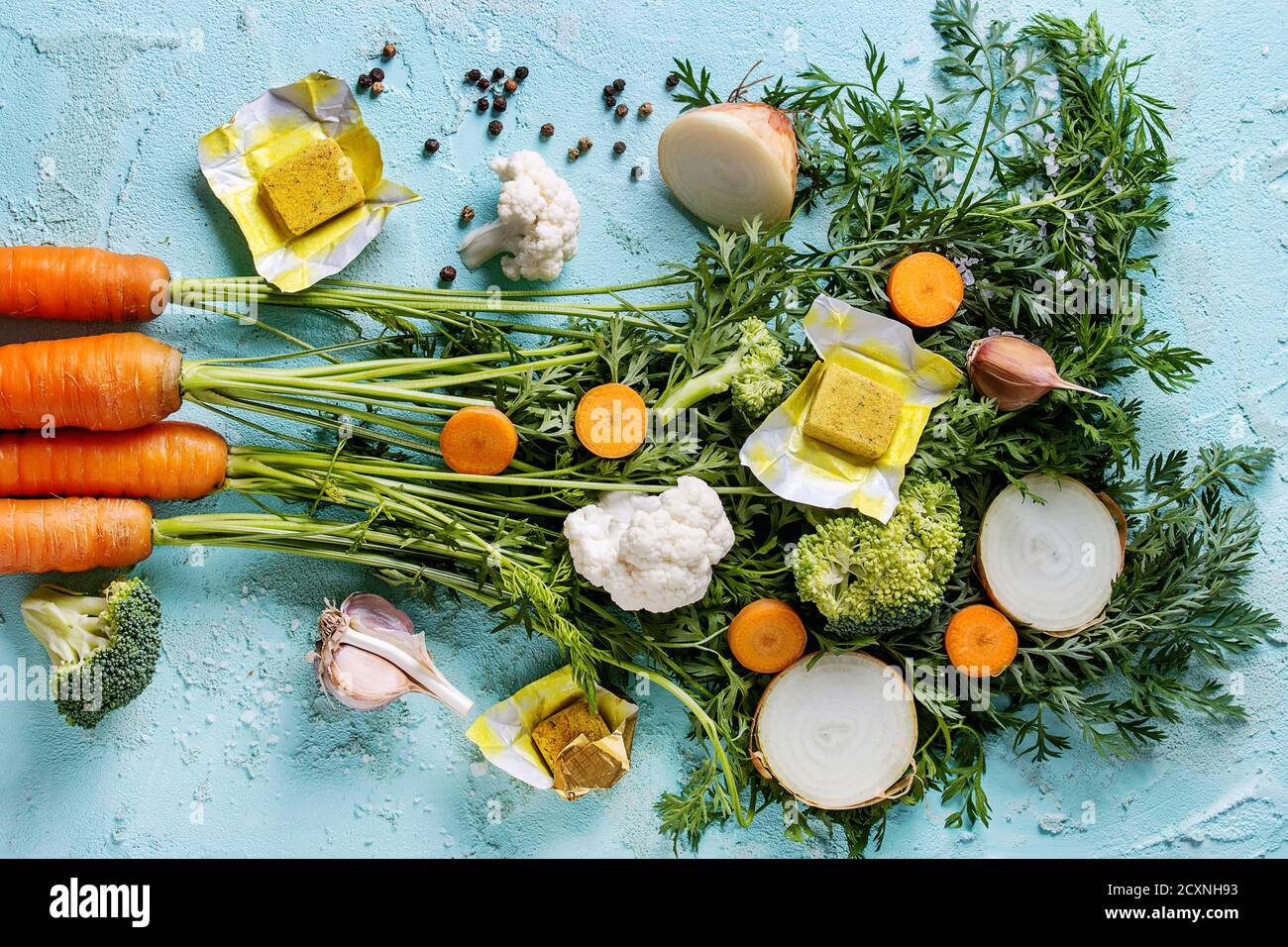 Raw vegetables and bouillon cubes for cooking soup. Young carrot with