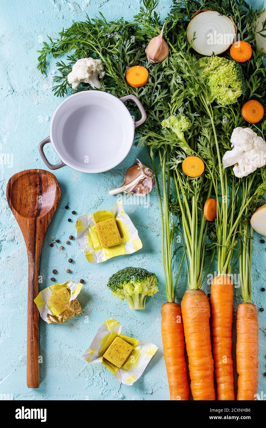 Raw vegetables and bouillon cubes for cooking soup. Young carrot with