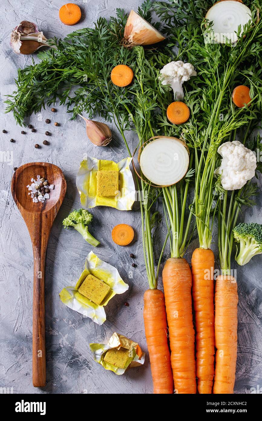 Raw vegetables and bouillon cubes for cooking soup. Young carrot with