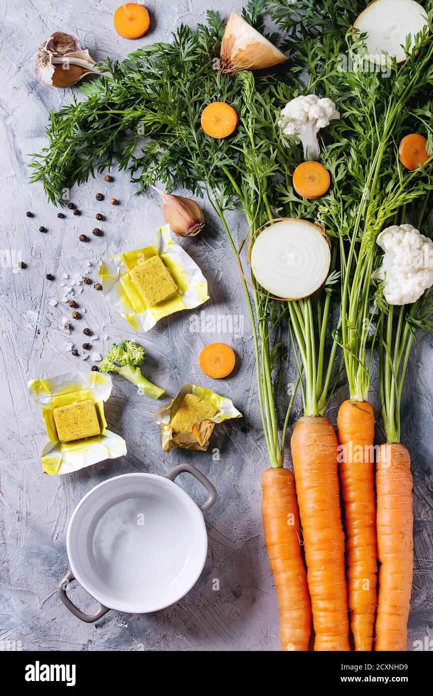 Raw vegetables and bouillon cubes for cooking soup. Young carrot with