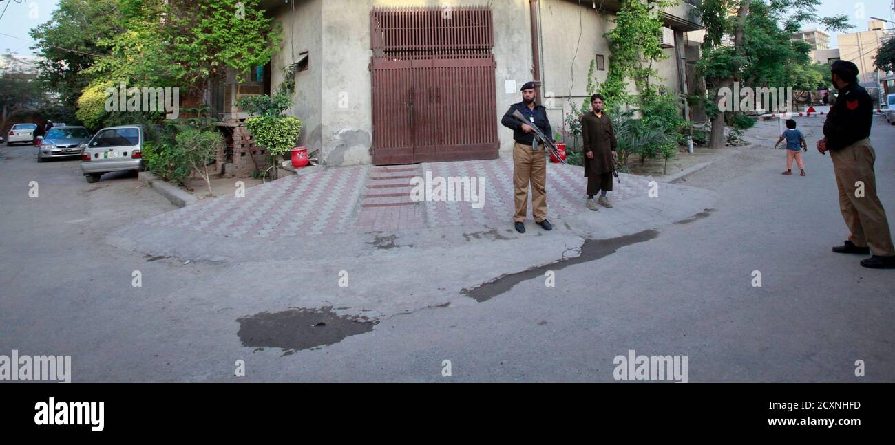 A police officer and private security guard stand outside the residence of  Hafiz Saeed, the head of Jamaat-ud-Dawa and founder of Lashkar-e-Taiba, in  Lahore April 3, 2012. The United States has put