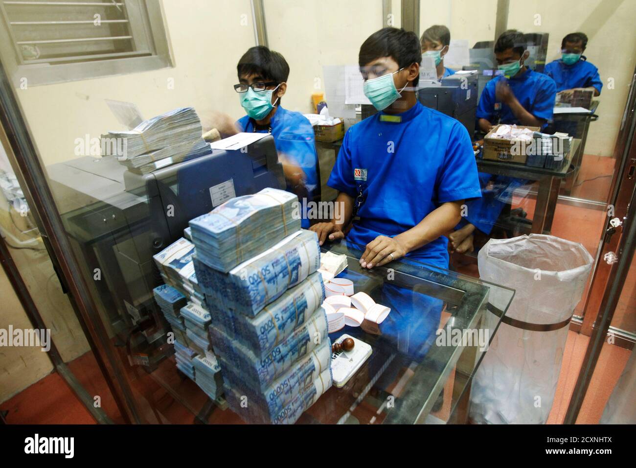 Bank employees sort rupiah banknotes at the Bank National ...