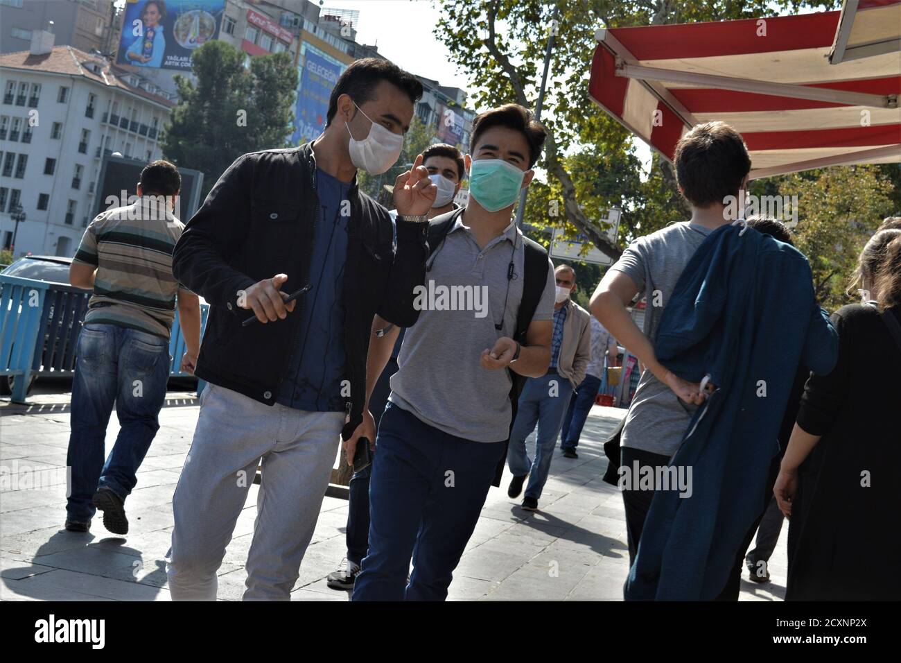 Ankara, Turkey. 1st Oct, 2020. Two young men wearing protective face masks walk along a street in Sihhiye district amid the coronavirus (COVID-19) outbreak. Turkish Minister of Health Fahrettin Koca admitted on September 30 that asymptomatic cases of the coronavirus are deliberately excluded from daily reports. The minister's statement came after the revelation of a document showing nearly 20 times more cases than the official daily figures. Credit: Altan Gocher/ZUMA Wire/Alamy Live News Stock Photo
