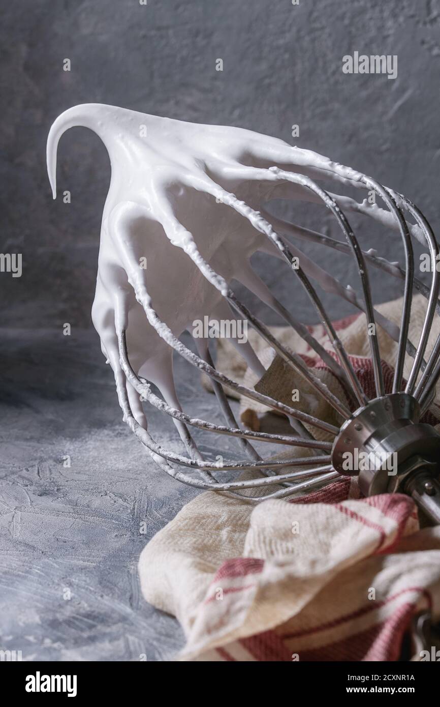 Process of cooking meringue. Whipped egg whites on mixer whisk on linen
