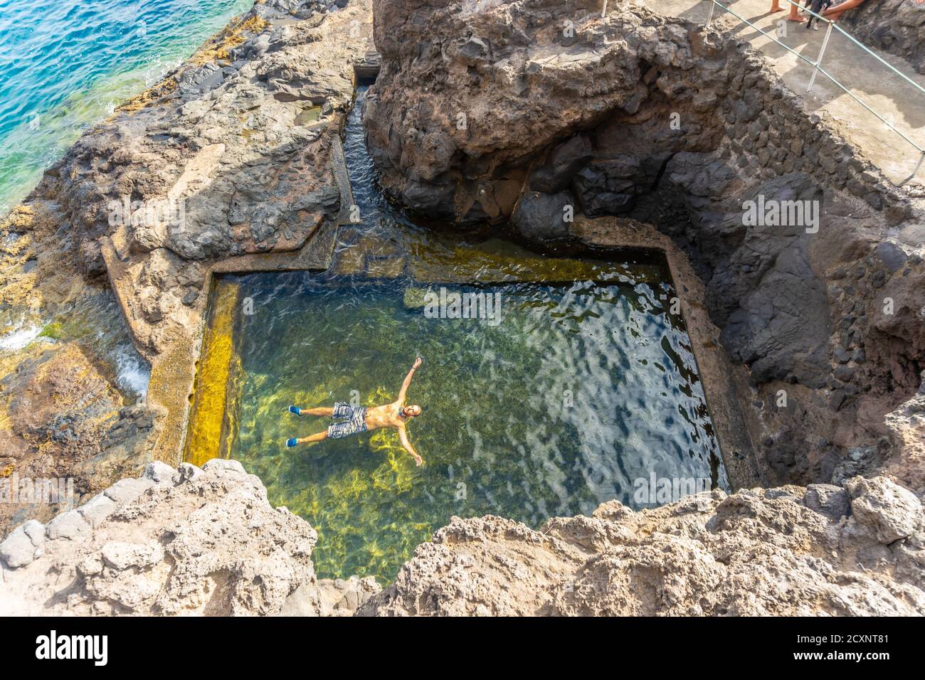 Young male enjoying a natural sea pool in the cove of Puerto de Puntagorda Stock Photo