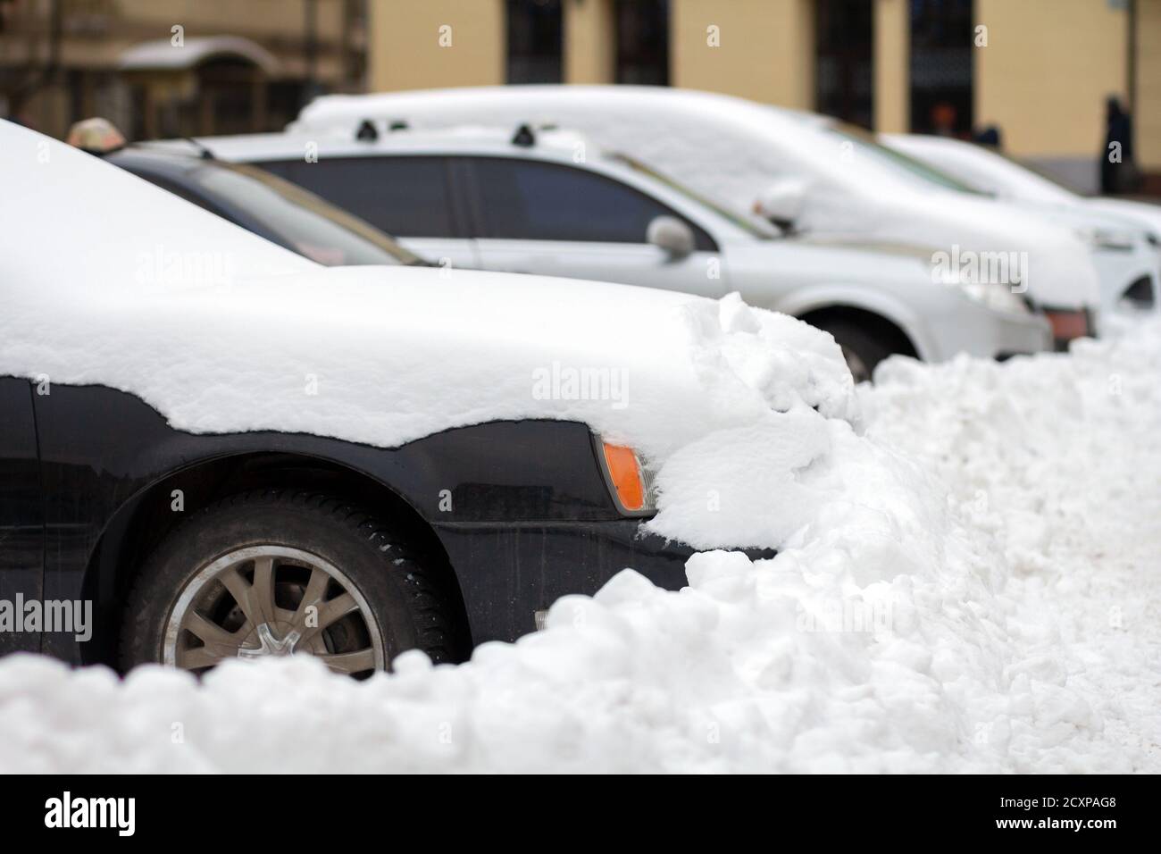 Cars parked on a side of city street covered with snow in winter Stock ...