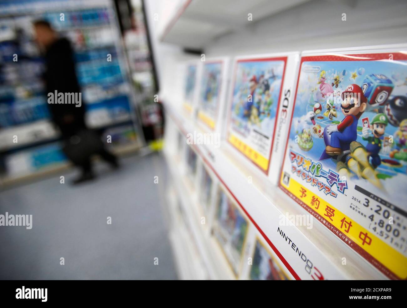 A man looks at items and accessories for Nintendo Co's Wii U game consoles,  as its 3DS portable game console software are displayed at an electronics  retail store in Tokyo January 20,