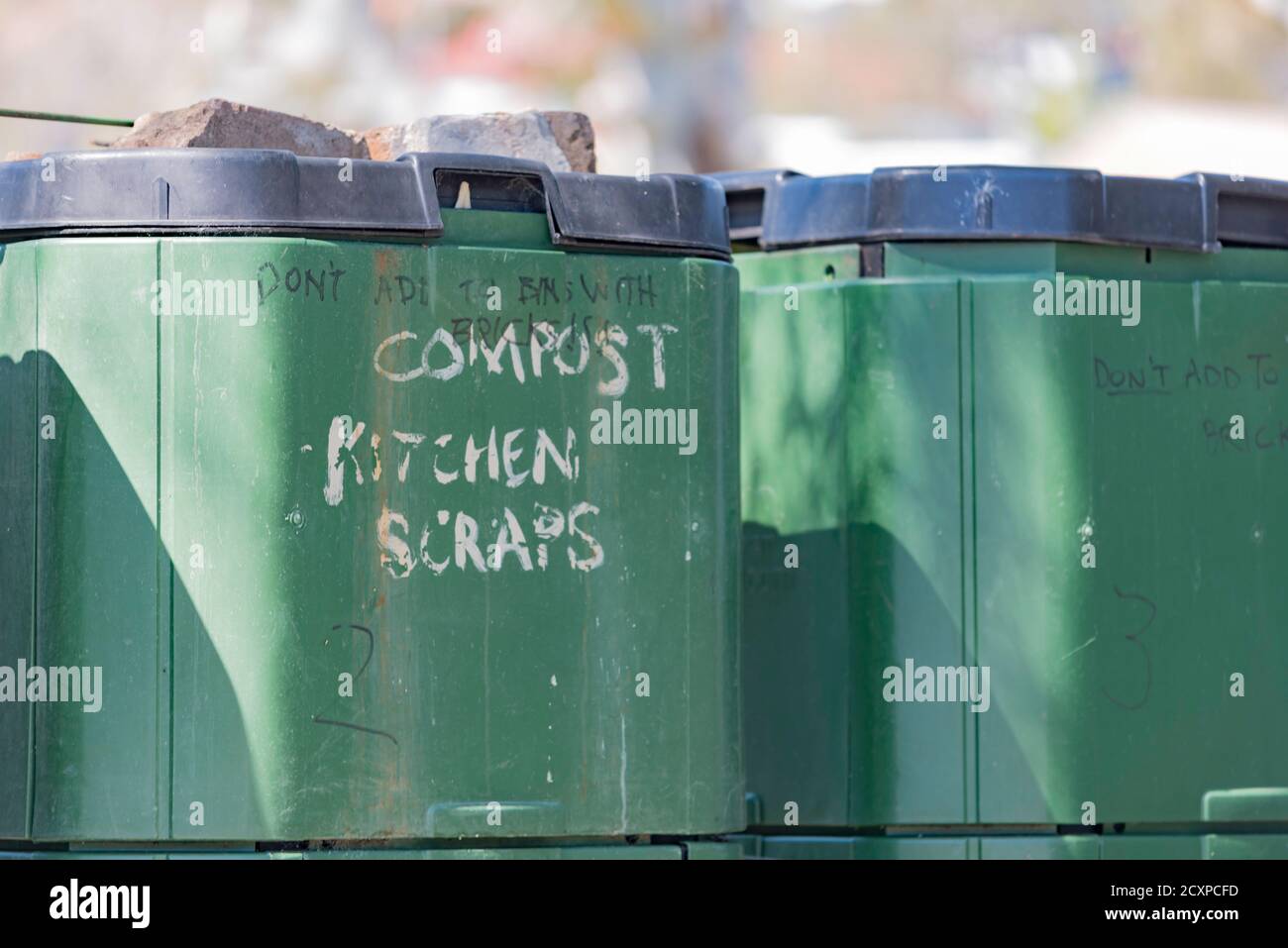 A close-up of two large green compost bins for vegetable scraps in a community garden in the Sydney suburb of Annandale, Australia Stock Photo