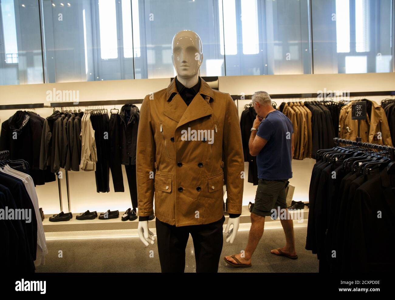 A man looks at clothes inside a Zara store in Madrid September 12, 2014.  Zara owner Inditex on September 17, 2014 posted a smaller-than-expected 2.4  percent drop in first-half net profit as