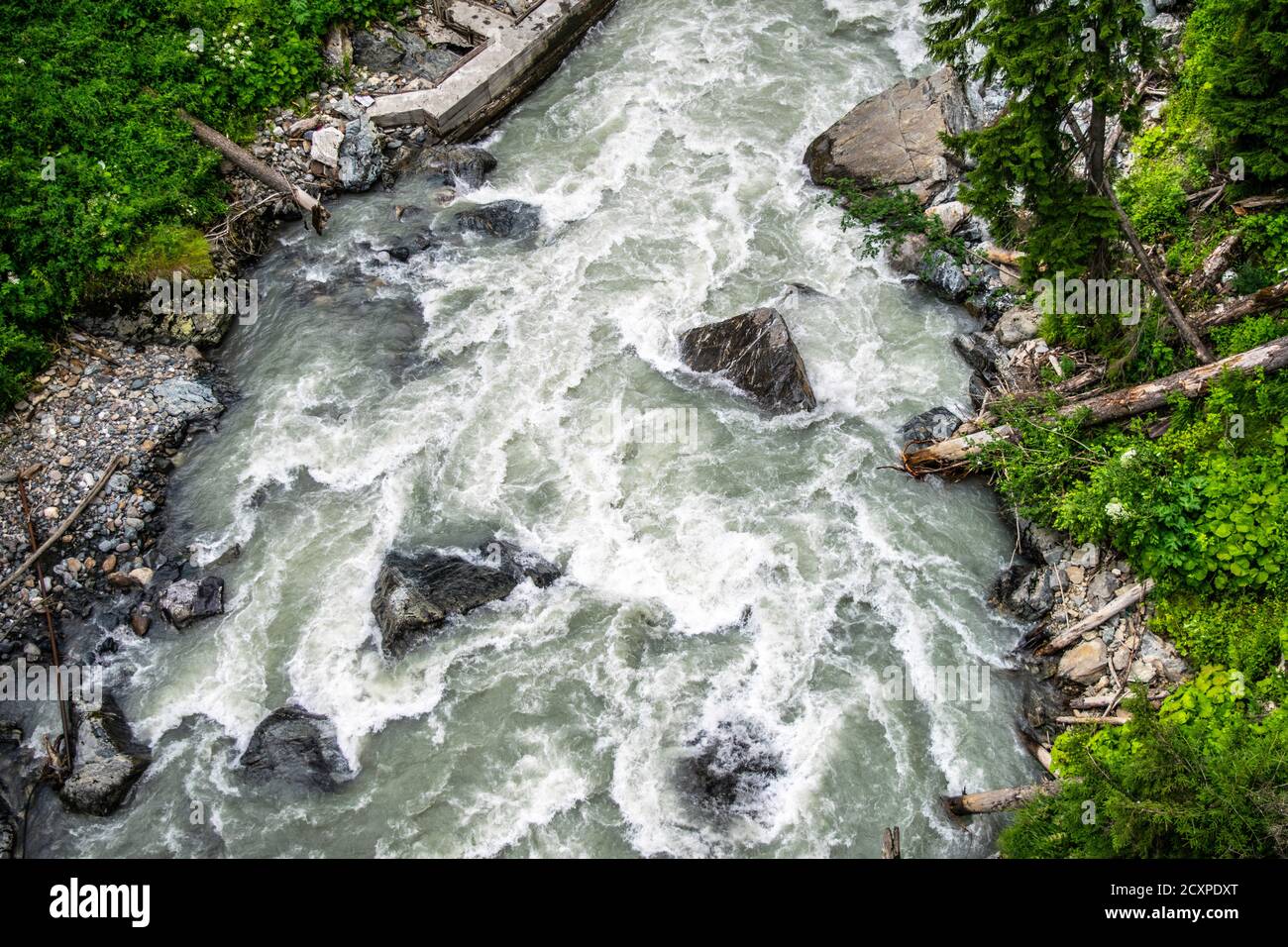 the water of a stormy mountain river flowing among stones and boulders ...