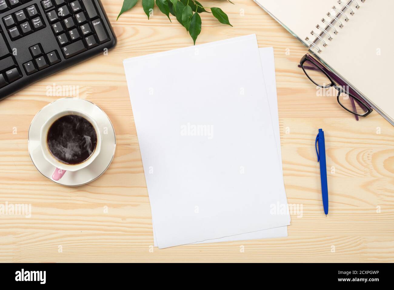 Flat lay, top view office table desk. Workspace with blank sheet of paper,  keyboard, office supplies, pencil, green leaf, and coffee cup on wooden tab  Stock Photo - Alamy, image size:1300x956
