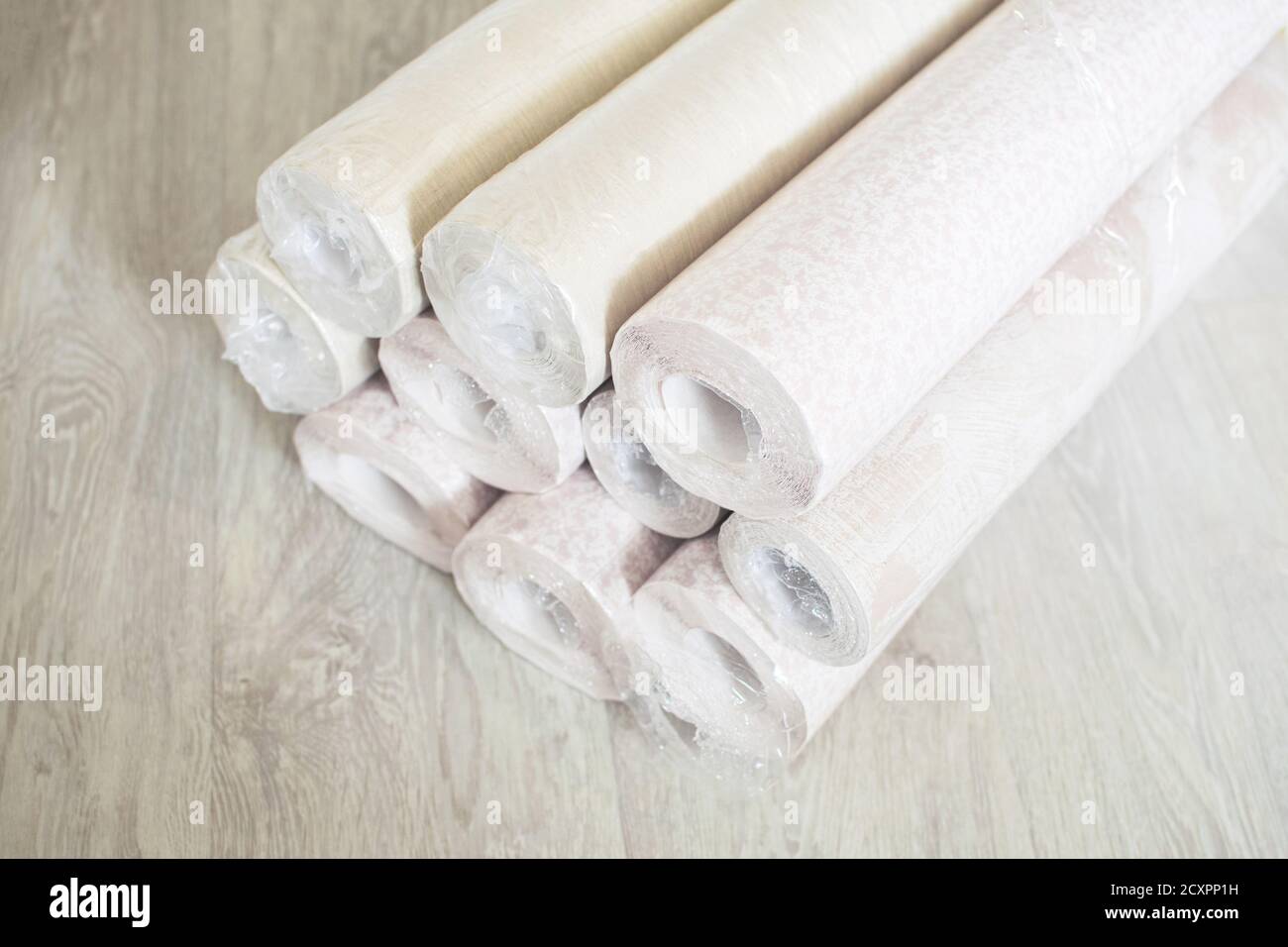 Several rolls of pastel paper wallpaper for wall renovation. Paperhangings on the floor. Wallpaper or paperhangings delivery. Stock Photo