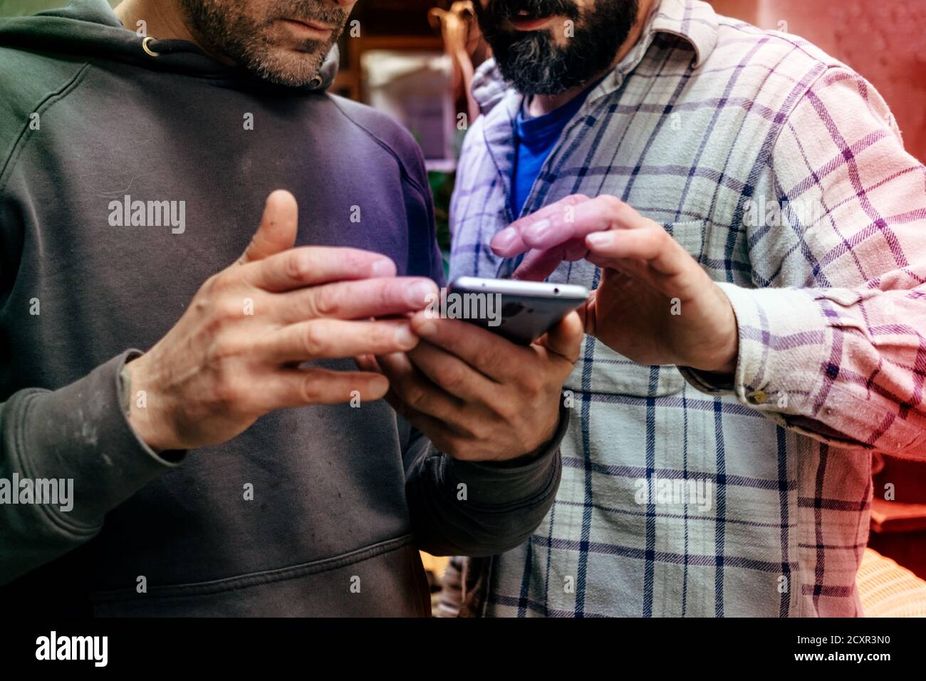 two men in casual wear focusing on the mobile phone Stock Photo