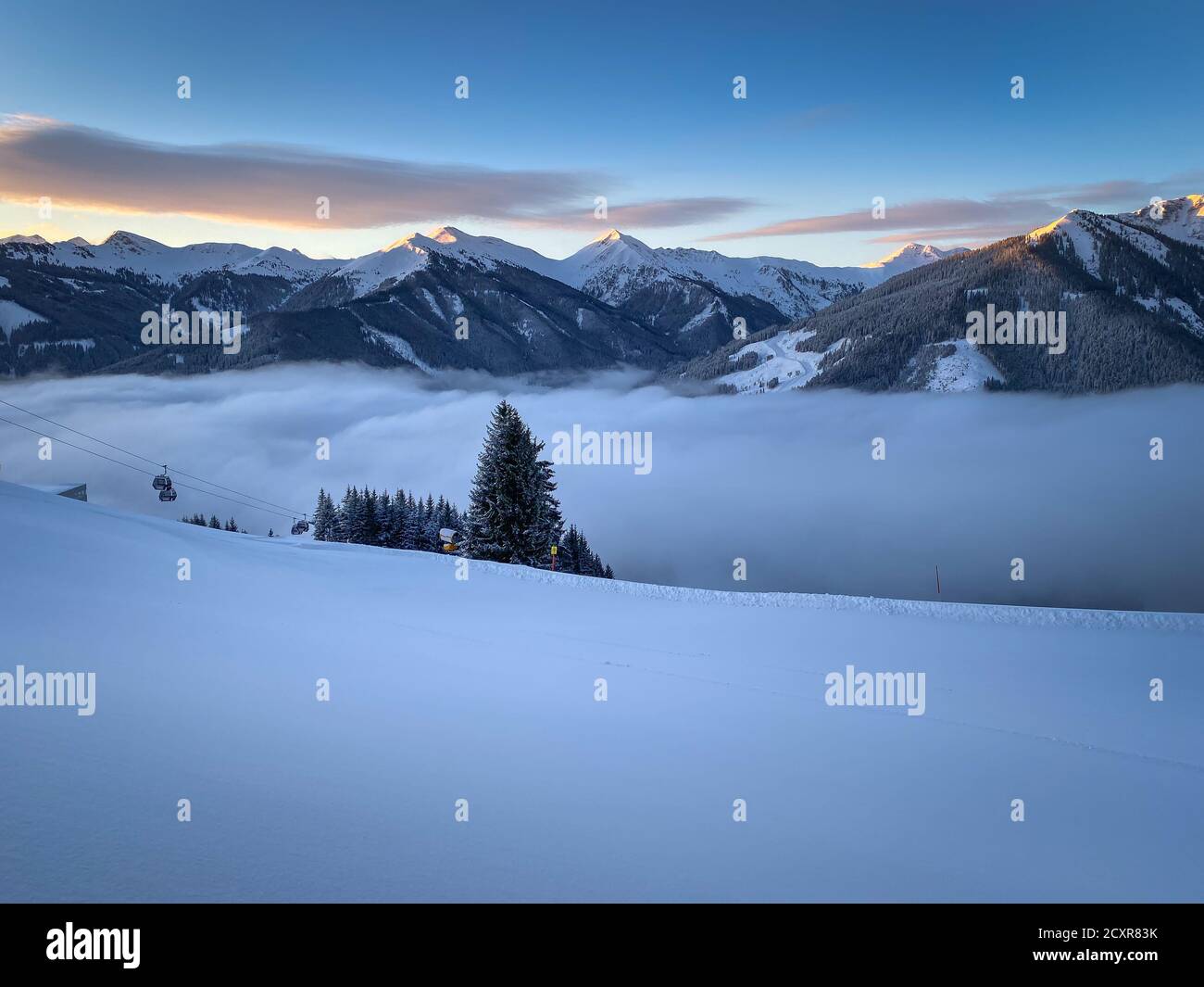 Scenic view to snow covered mountains and a blanket of clouds in the ski resort Saalbach Hinterglemm Stock Photo