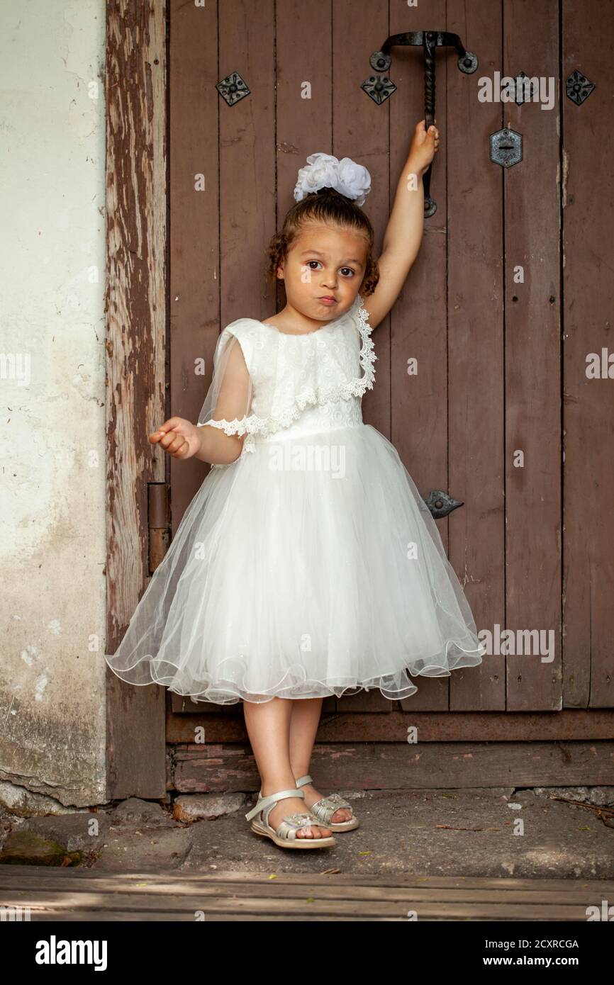 A little girl in a white dress of the bride on the nature in the park Stock Photo Alamy