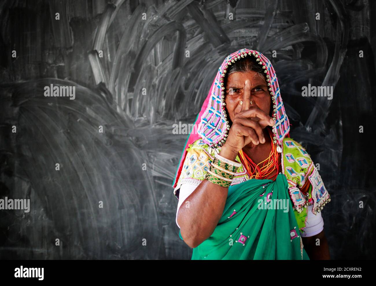 A tribal woman shows her ink-marked finger after voting at a polling centre during the seventh phase of India's general election, in Rangareddy district in the southern Indian state of Andhra Pradesh April 30, 2014. Around 815 million people have registered to vote in the world's biggest election - a number exceeding the population of Europe and a world record - and results of the mammoth exercise, which concludes on May 12, are due on May 16. REUTERS/Danish Siddiqui (INDIA - Tags: ELECTIONS POLITICS TPX IMAGES OF THE DAY) Stock Photo