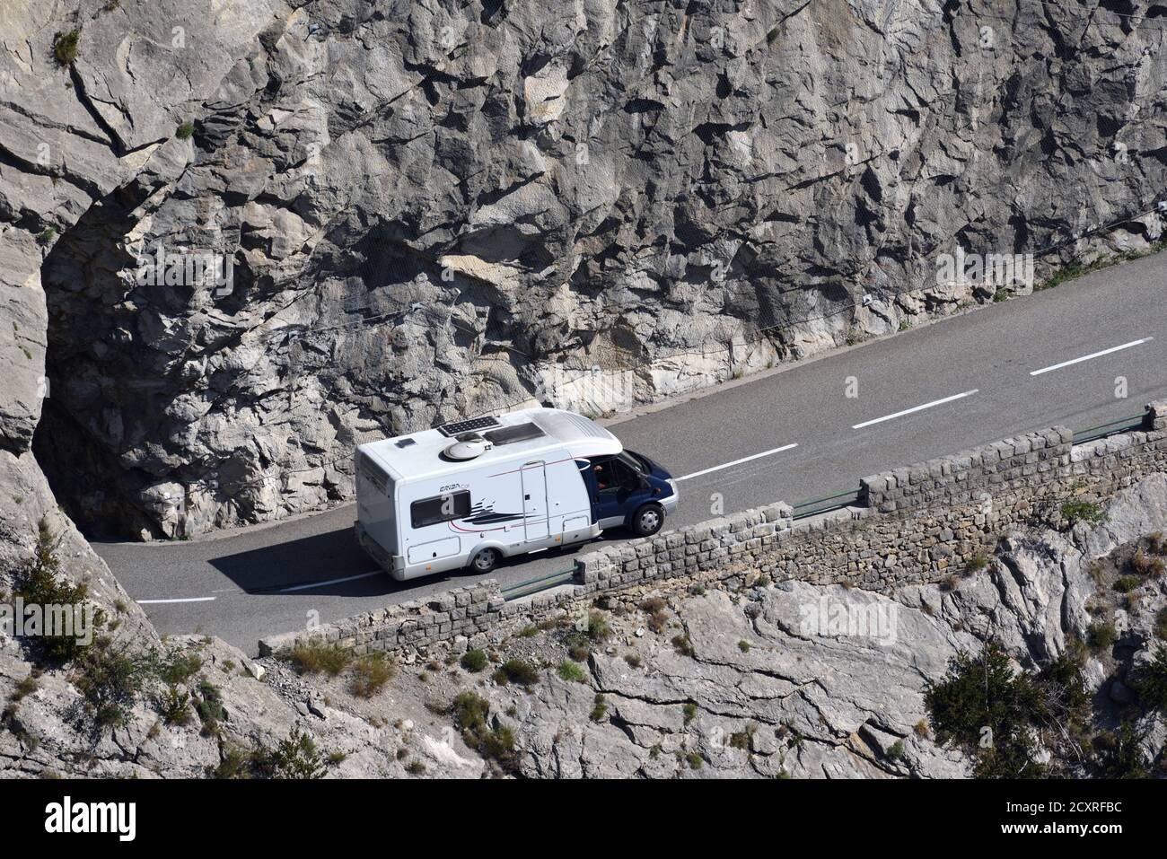 Campervan or Motor Caravan Driving Along Dangerous Narrow Mountain Road in Clue de Taulanne near Castellane Alpes-de-Haute-Provence Provence France Stock Photo