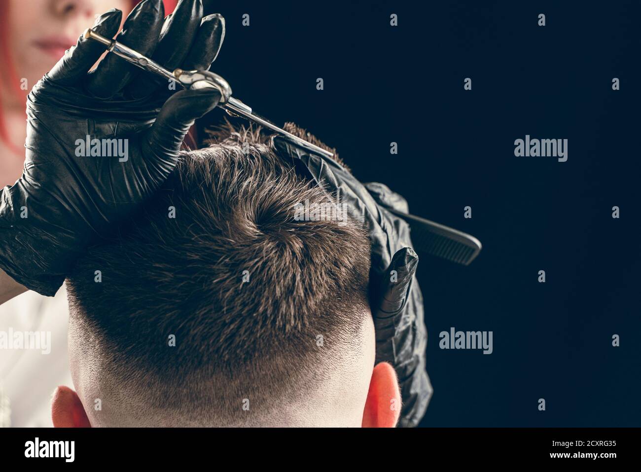 Barber skillfully cutting hair with scissors in a barbershop