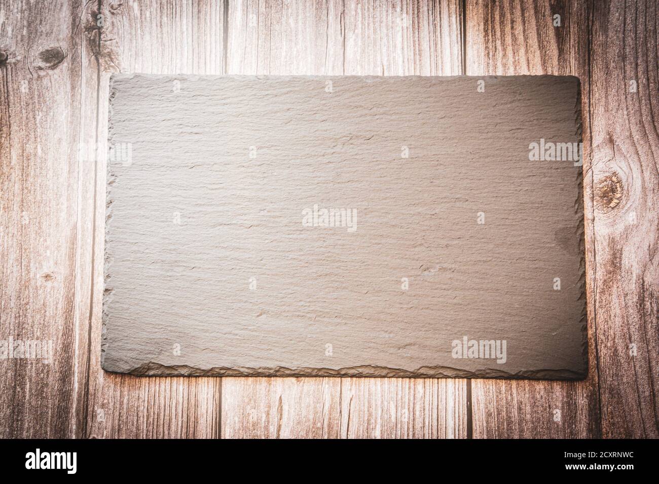A slate plate on a wooden background with copy space Stock Photo