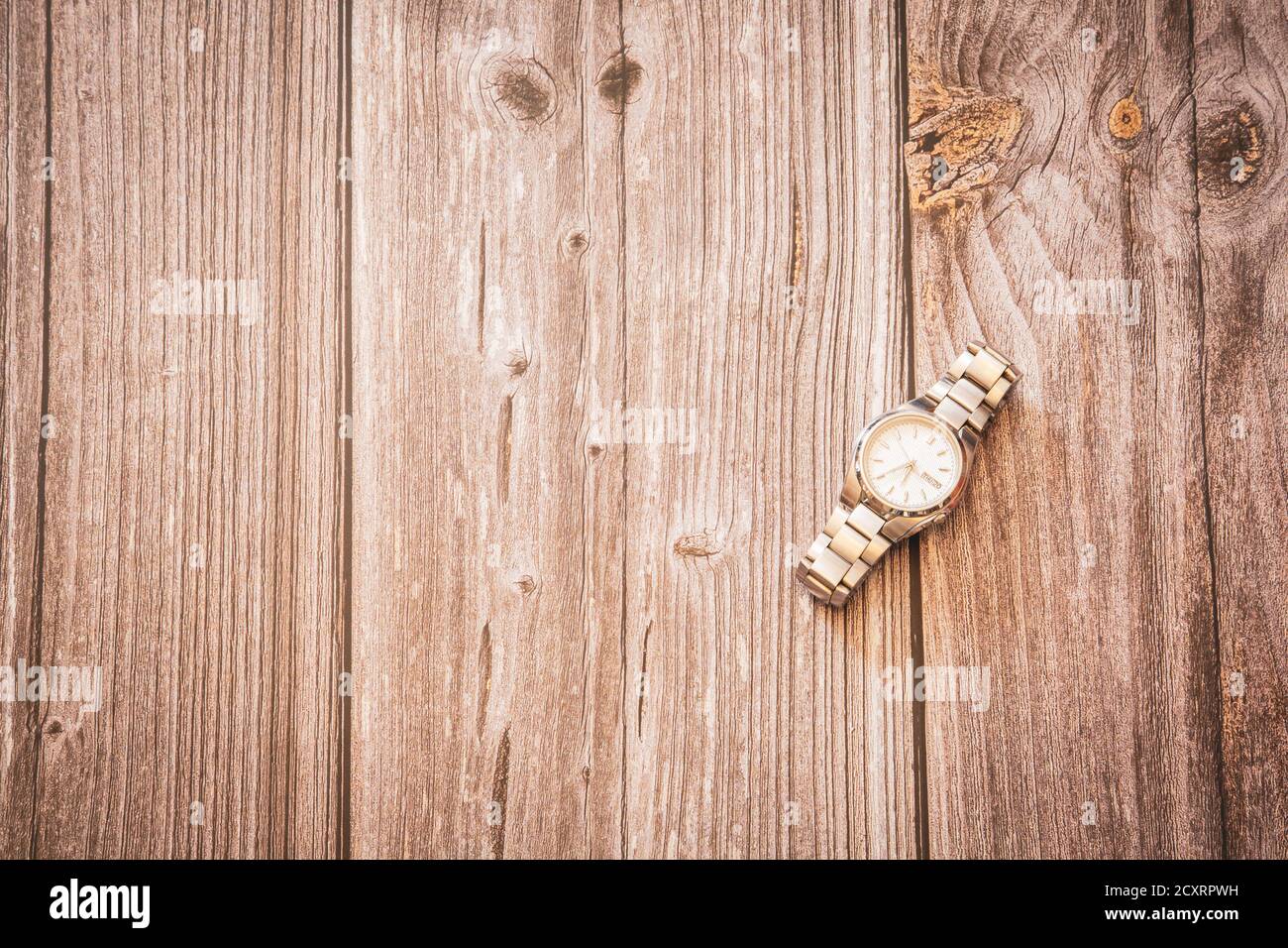 A men's silver wrist watch on a rustic wooden background with copy space Stock Photo