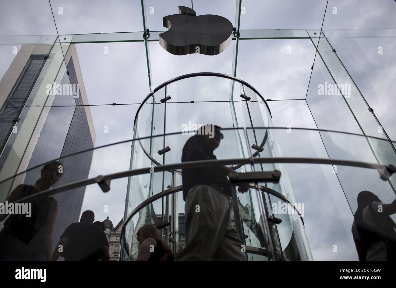 Customers enter the Apple store on 5th Avenue beneath an Apple logo in the Manhattan borough of New York City, July 21, 2015. Apple Inc said it is experiencing some issues with its App Store, Apple Music, iTunes Store and some other services. The company did not provide details but said only some users were affected. Checks by Reuters on several Apple sites in Asia, Europe and North and South America all showed issues with the services. REUTERS/Mike Segar Stock Photo