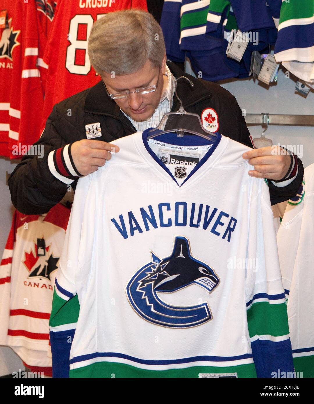 Canadian Prime Minister Stephen Harper looks over a Vancouver Canucks Jersey  from Sport Chek in Richmond, British Columbia April 17, 2011. The jersey is  for his son, Ben, who turns 15 this