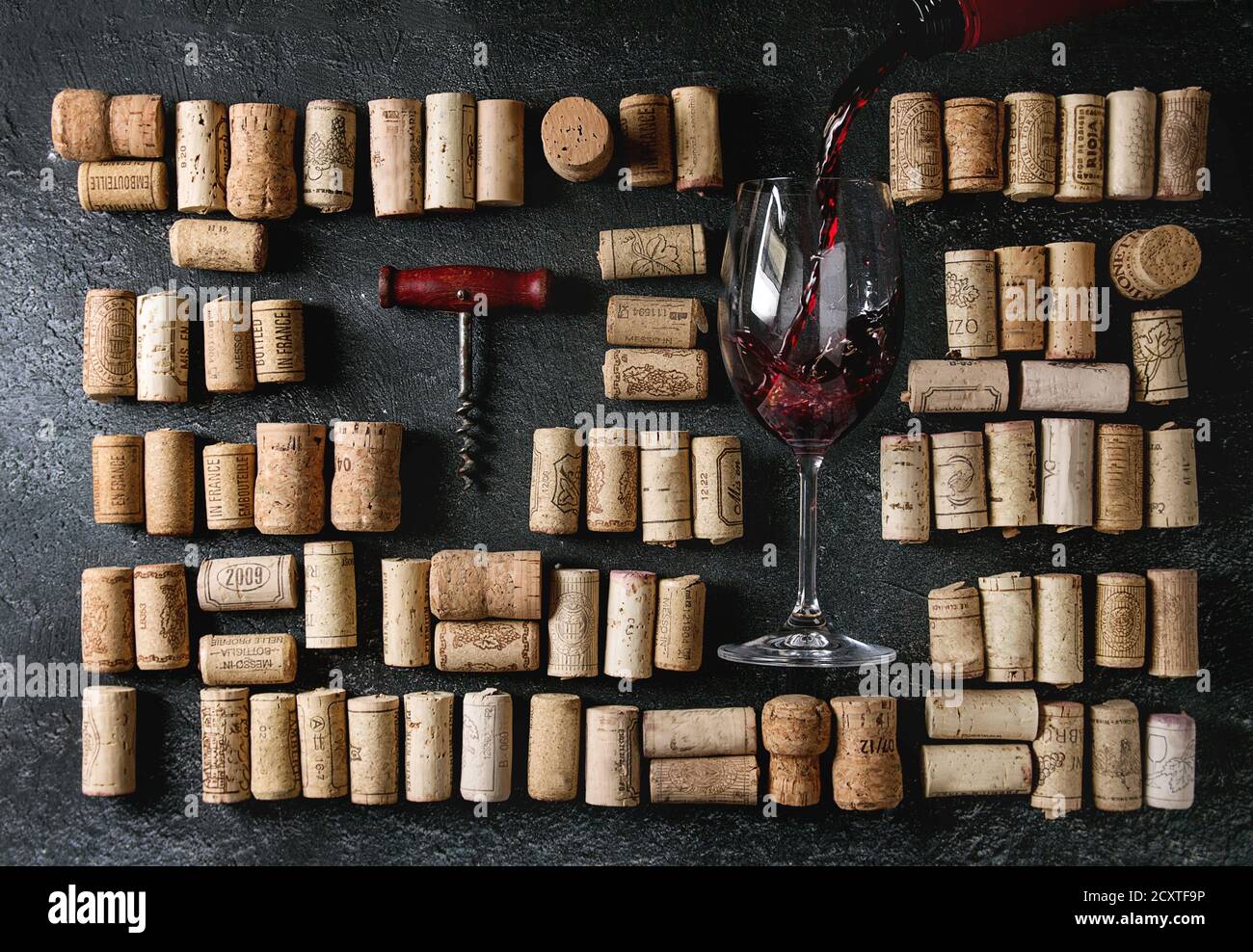 Big set of used wine corks in rows with vintage corkscrew and pouring