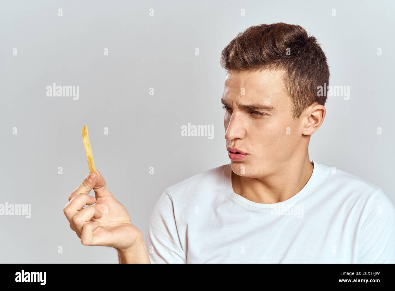 emotional man holding fries calories fast food light background white t