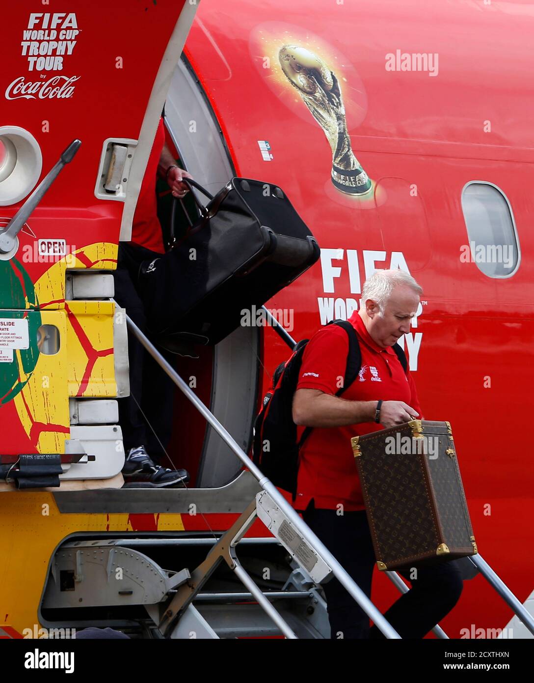 A man disembarks with the 2014 FIFA World Cup trophy at Subang airport  outside Kuala Lumpur January 3, 2014. The trophy will travel to 88  countries and territories, covering around 150,000km (92,000