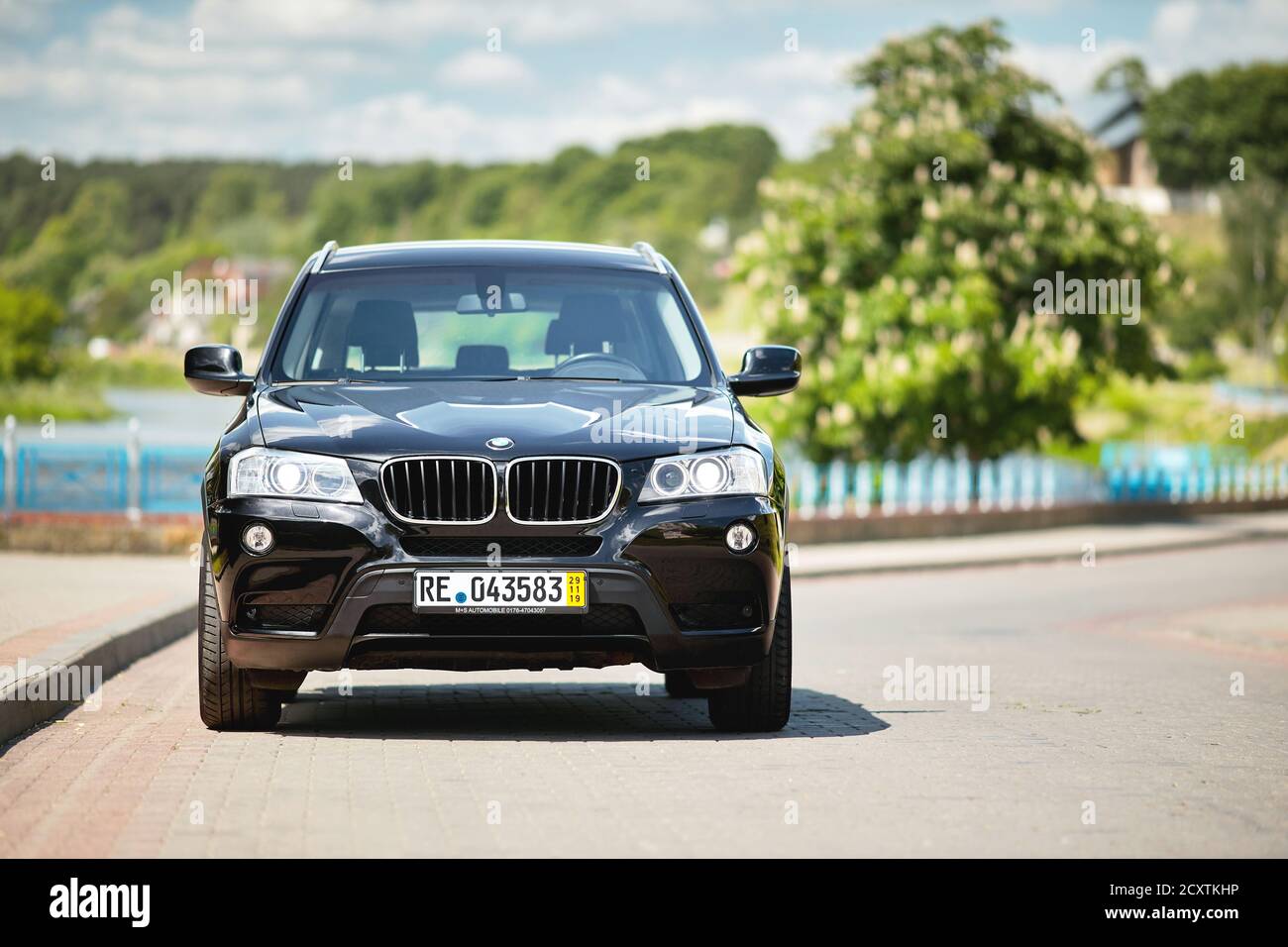 GRODNO, BELARUS - JUNE 2020: BMW X3 II F25 2.0i xDrive selective focus front view with wheels standing straight outdoors on sunny road summer city Stock Photo