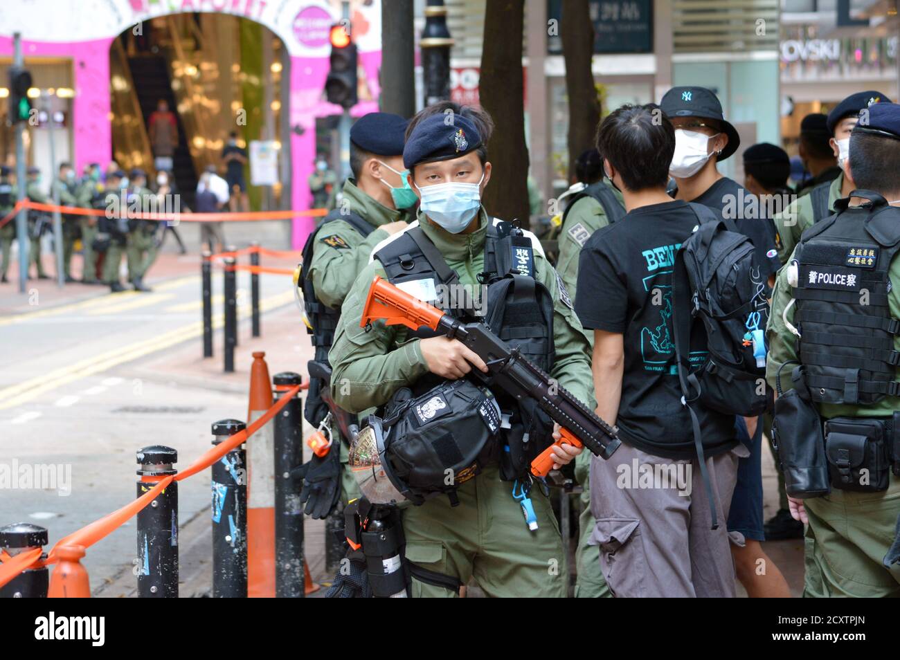 A Hong Kong Police Force officer holds a weapon in the Causeway Bay shopping district on National Day, 1 October 2020 Stock Photo
