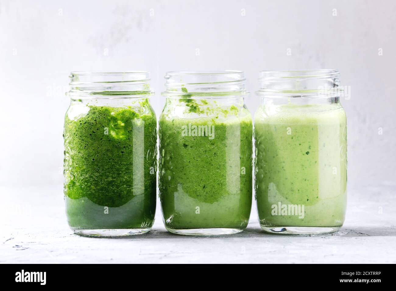 Variety of three color green spinach kale apple yogurt smoothie in