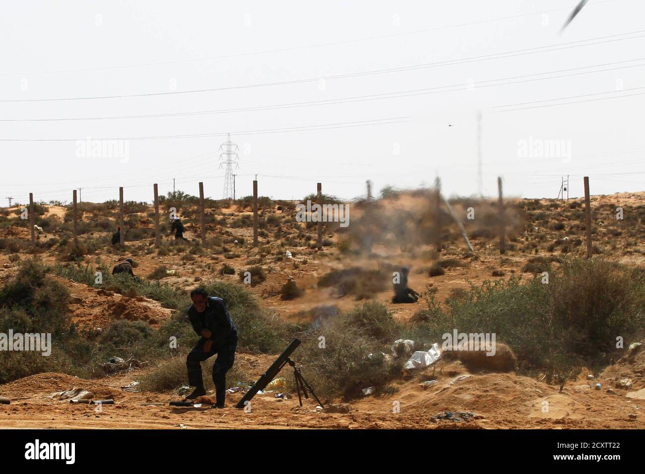 Rebels fire a mortar towards forces loyal to Muammar Gaddafi some 120 km (75 miles) east of Sirt in eastern Libya March 28, 2011. REUTERS/Finbarr O'Reilly (LIBYA - Tags: CONFLICT CIVIL UNREST POLITICS IMAGES OF THE DAY) Stock Photo