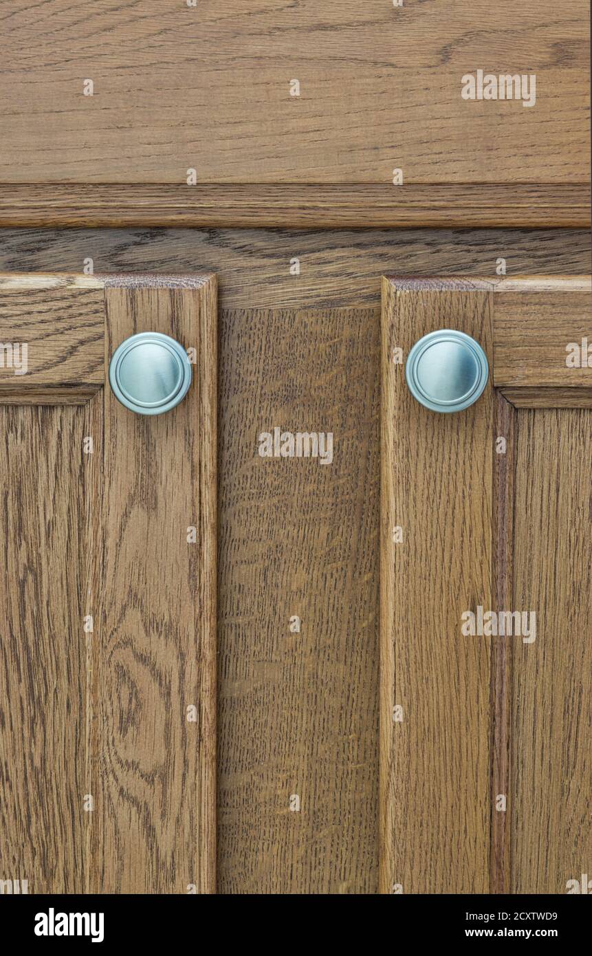 Brown wooden cupboard doors with silver handles, wood stain color swatch in vertical format. Stock Photo