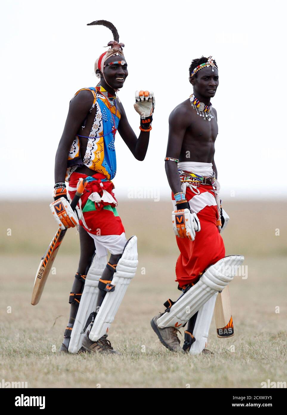 Sonyanga Olengais (R), captain of the Maasai Cricket Warriors, and his teammate Thomas Takare walk during their T20 cricket match against the Ambassadors of Cricket from India in Ol Pejeta conservency in Laikipia national park, June 6, 2013. The Maasai Cricket Warriors are role models in their communities where they actively campaign against retrogressive and harmful cultural practices, such as female genital mutilation and early childhood marriages, while fighting to eradicate discrimination against women in Maasailand. Through cricket, they hope to promote healthier lifestyles and to also sp Stock Photo