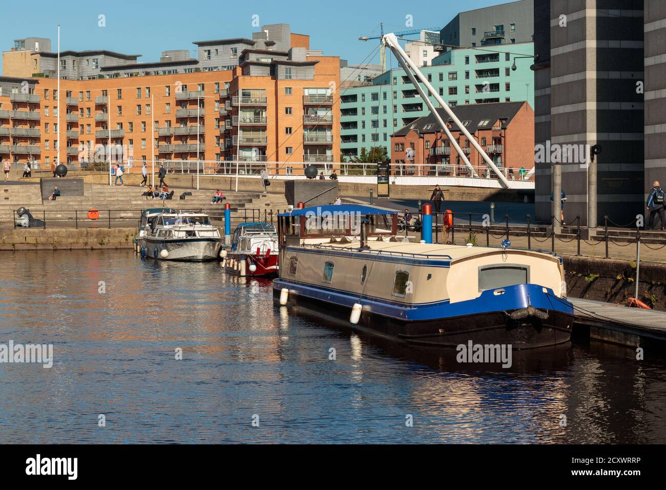 View of unidentified people and canal boats moored in Leeds Dock Stock Photo