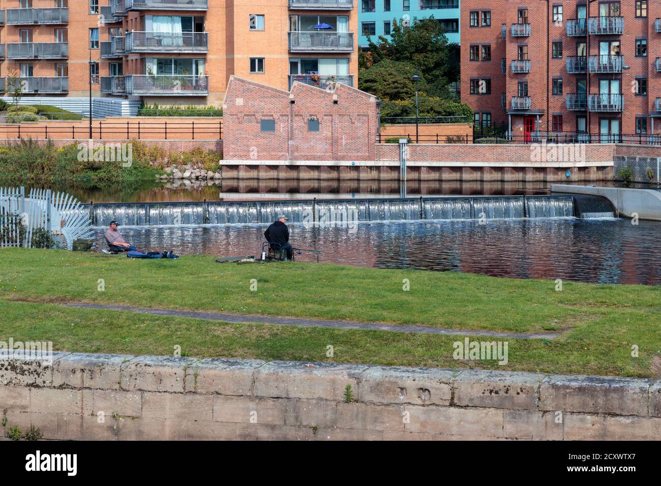 View of unidentified men fishing on River Aire Island, Leeds Stock Photo