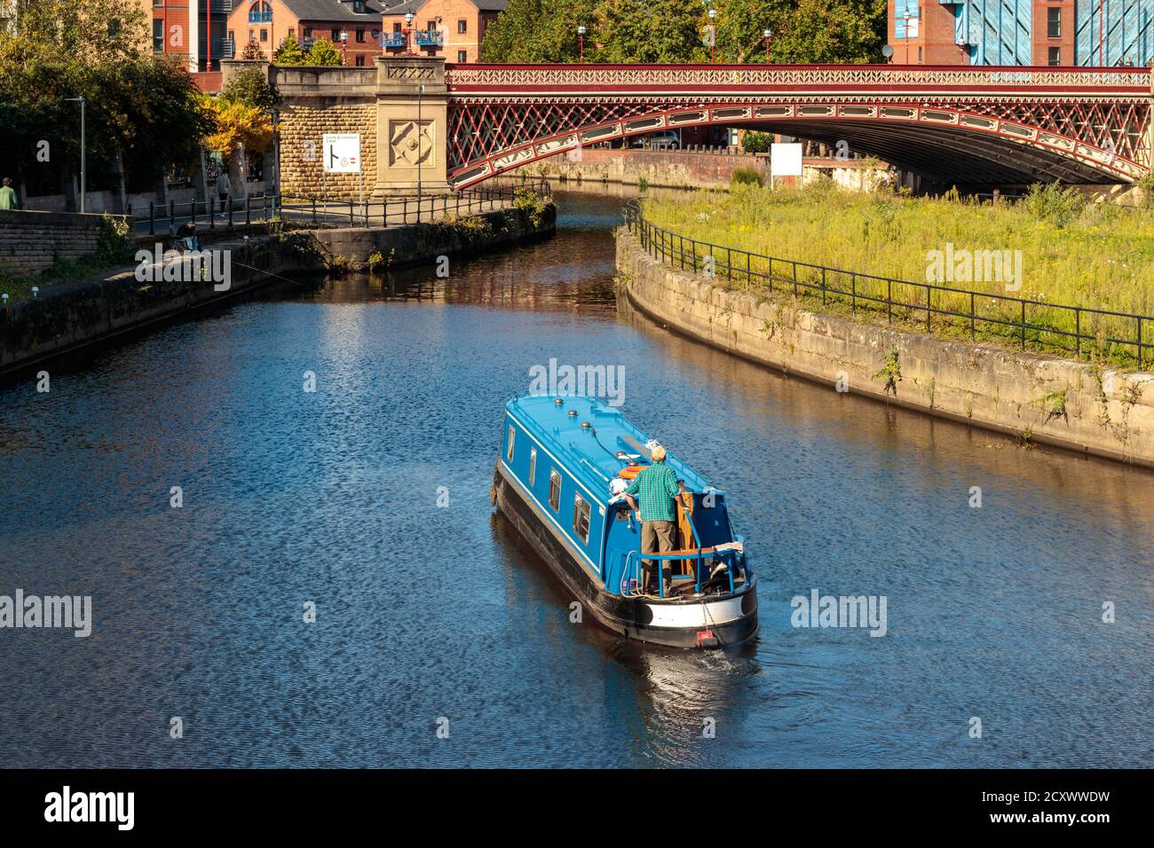 View of unidentified people and a canal boat navigating the River Aire Island lock, Leeds Stock Photo
