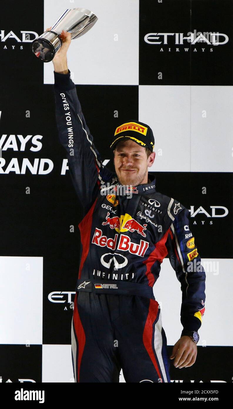 Red Bull Formula One driver Sebastian Vettel of Germany holds up his trophy  during the podium ceremony after the Abu Dhabi F1 Grand Prix at the Yas  Marina circuit on Yas Island