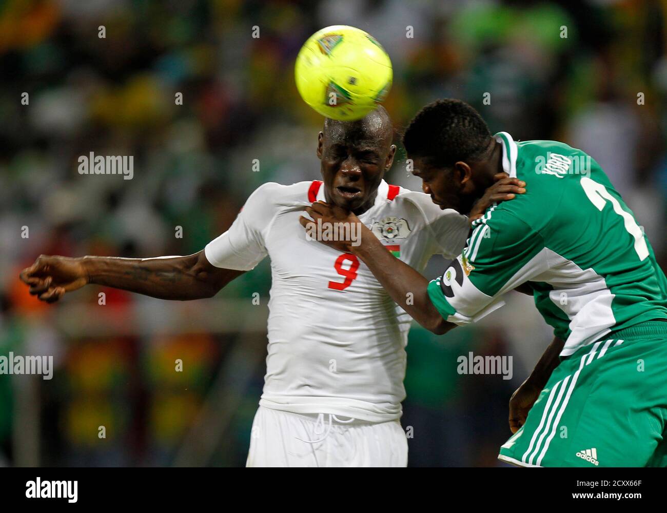 Burkina Faso's Moumouni Dagano (L) contests the ball with Nigeria's Joseph Yobo (R) during their African Nations Cup (AFCON 2013) Group C soccer match in Nelspruit, January 21, 2013. REUTERS/Thomas Mukoya (SOUTH AFRICA - Tags: SPORT SOCCER) Stock Photo