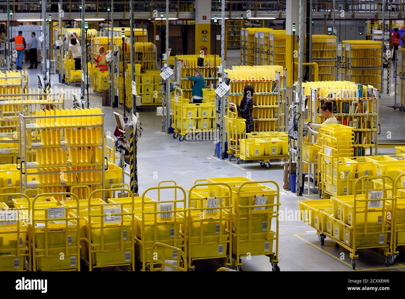 Workers collect items at Amazon's logistics centre in Graben near Augsburg  December 16, 2013. Workers at Amazon.com's German operations were set to go  on strike on Monday, in the middle of the