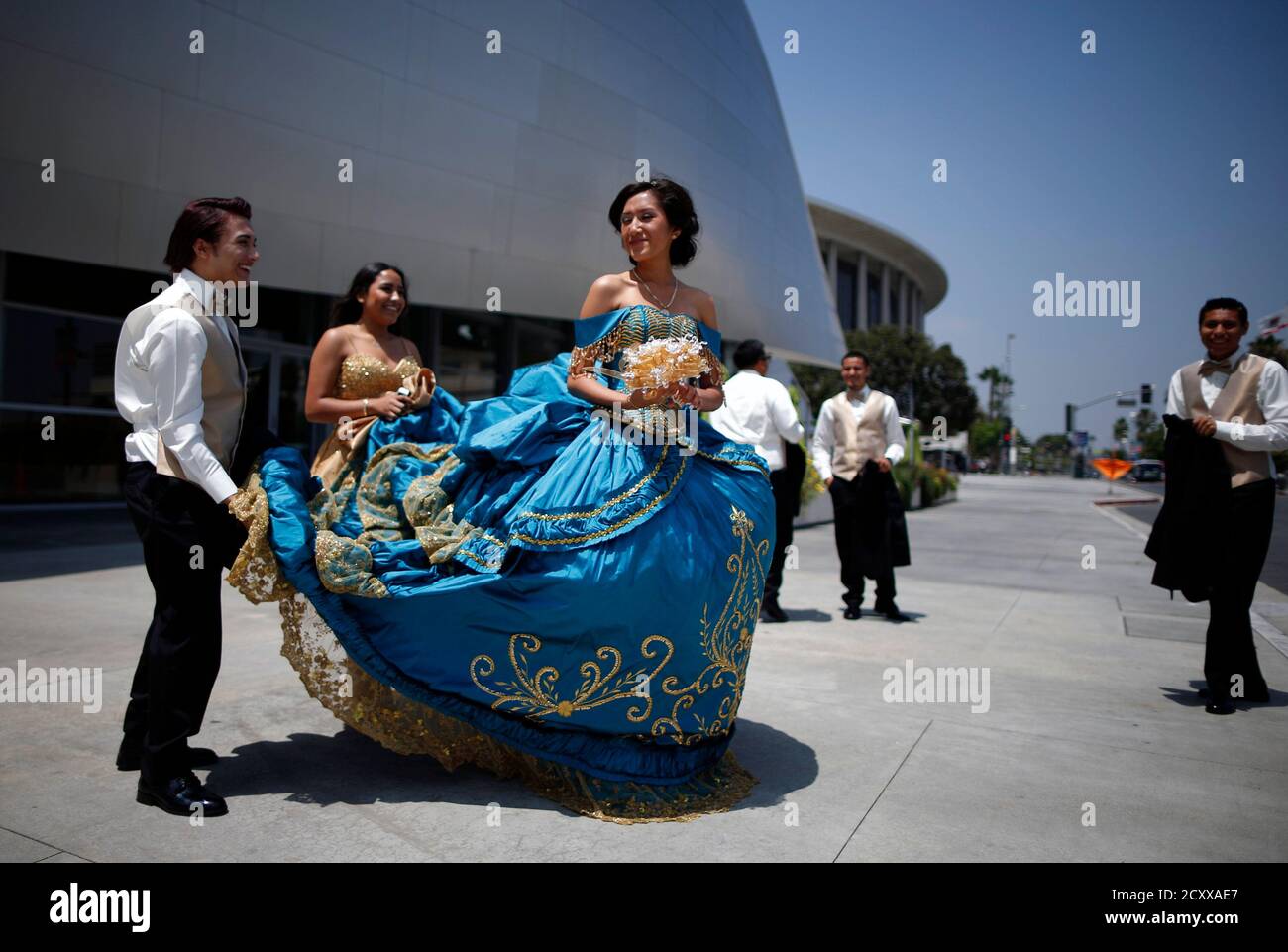 Jocelyn Campos (C), 15, wears her quinceanera dress as she stands with her attendants outside Disney Hall in Los Angeles, California June 25, 2014. Quincea?era is a rite of passage celebrated on the fifteenth birthday of many female Hispanic teenagers. REUTERS/Lucy Nicholson  (UNITED STATES - Tags: SOCIETY) Stock Photo