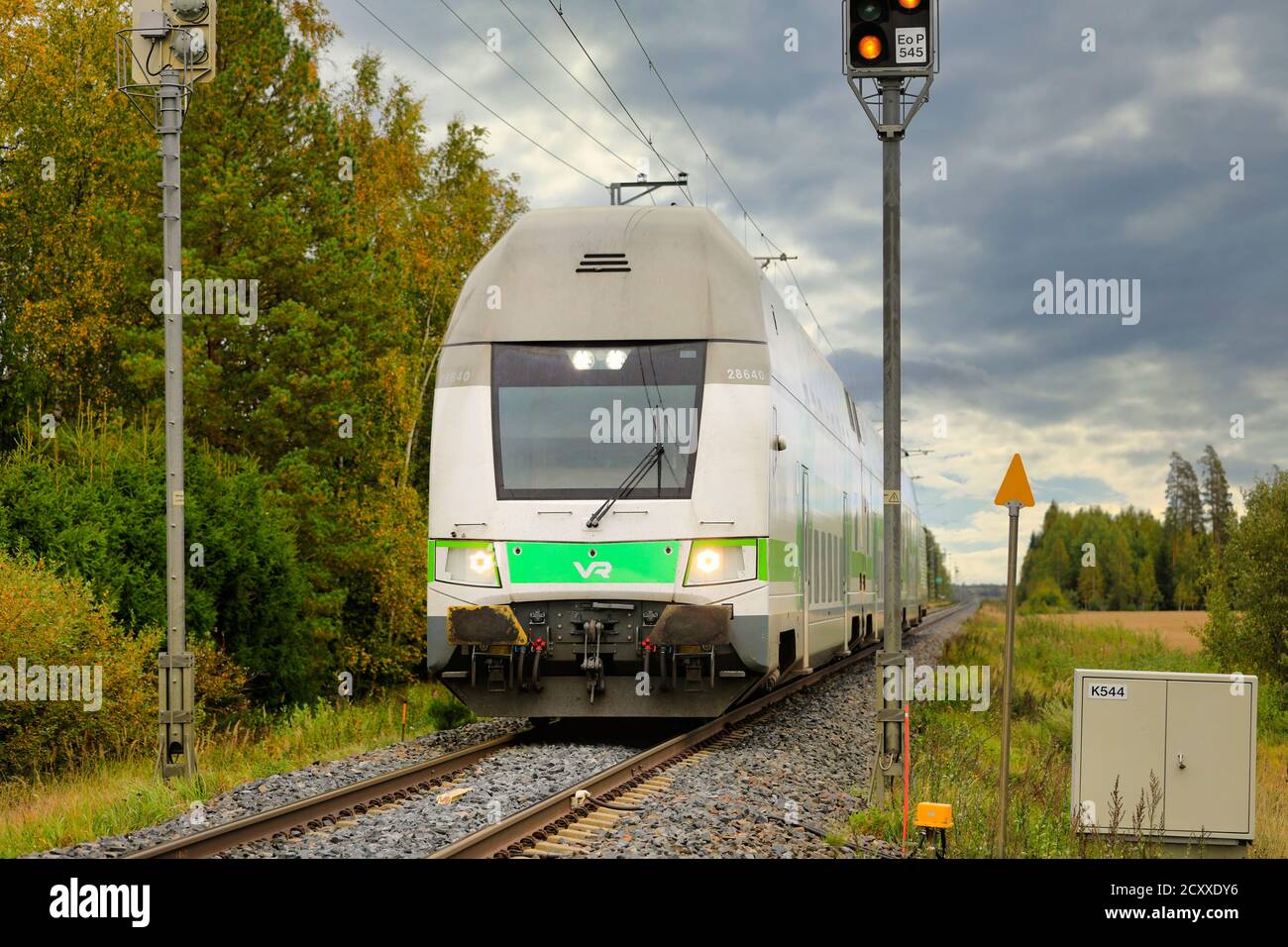 Modern VR Group Intercity electric 2 storey passenger train on the move at rural railroad crossing. Loimaa, Finland. September 18, 2020. Stock Photo