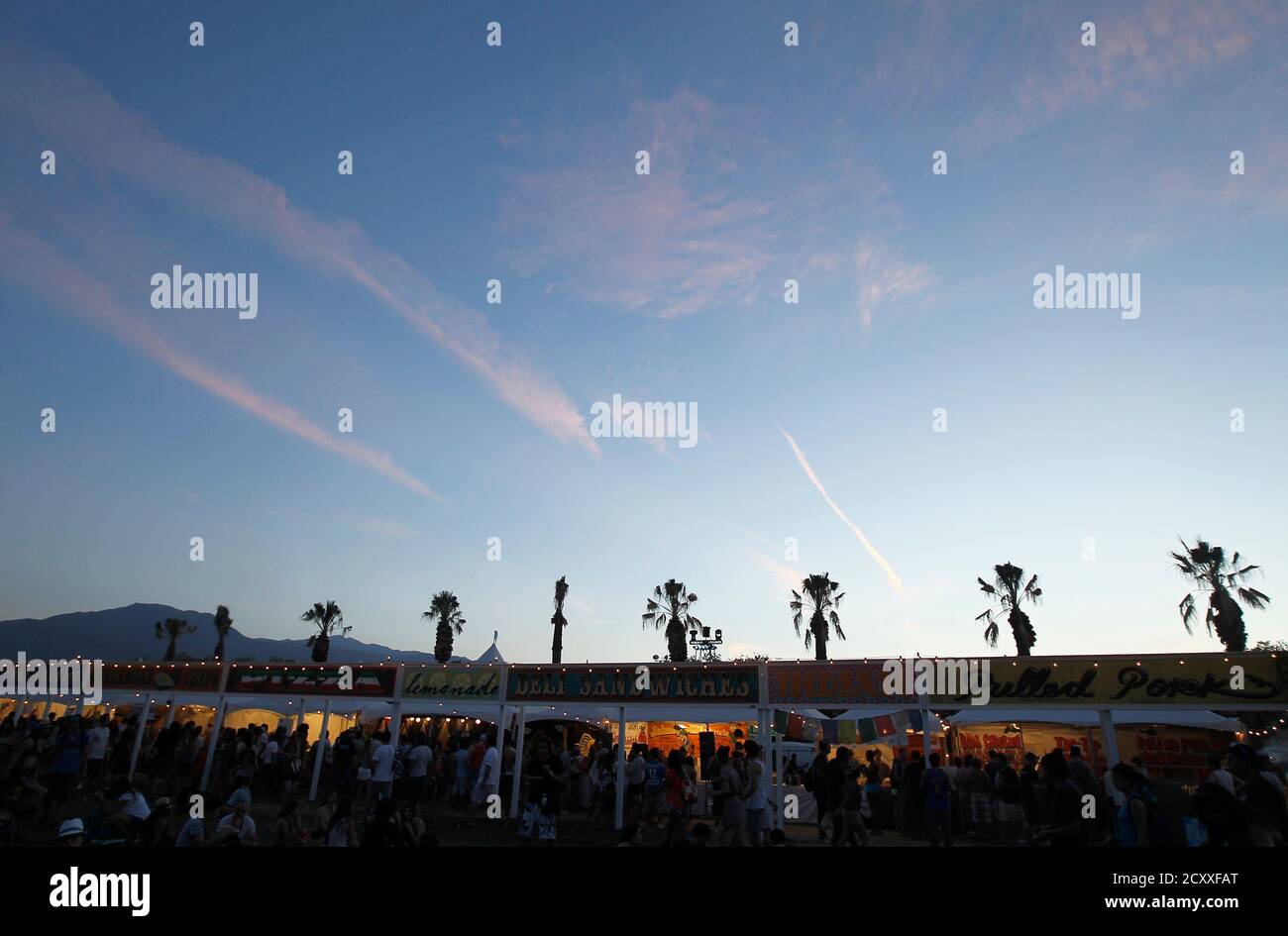 Concert-goers line up to order food from small food stands during the 2nd day of the Coachella Valley Music & Arts Festival in Indio, California April 16, 2011. REUTERS/Mike Blake (UNITED STATES - Tags: ENTERTAINMENT SOCIETY) Stock Photo